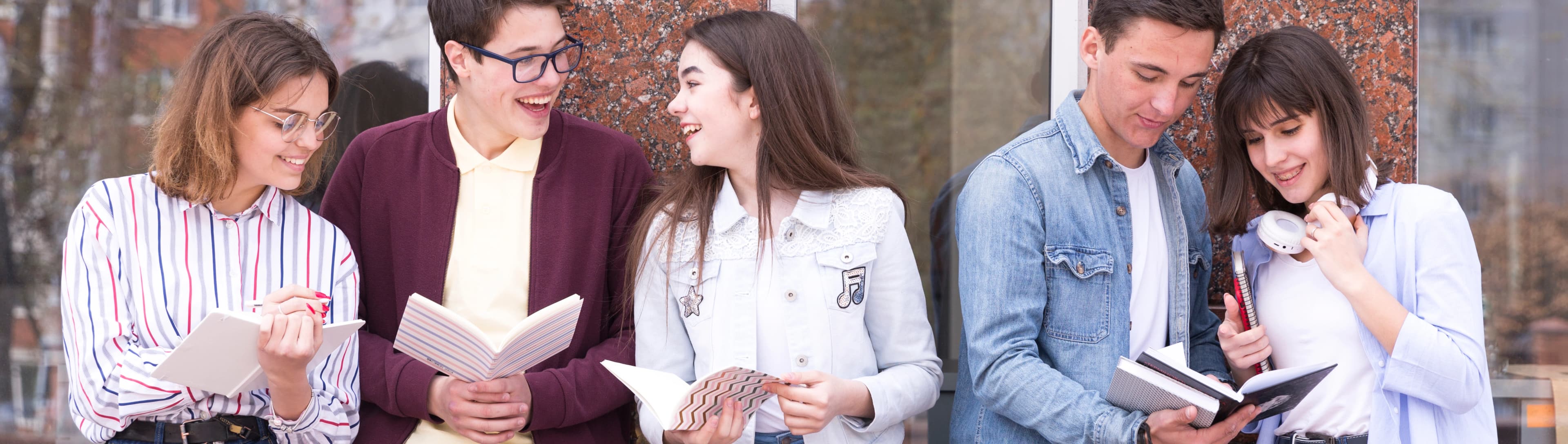 1765801221246-HERO-young-people-standing-with-books-reading-it-discussing-content.jpg